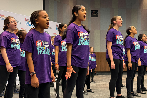 Children in purple JTF tshirts standing and singing in powerful pose