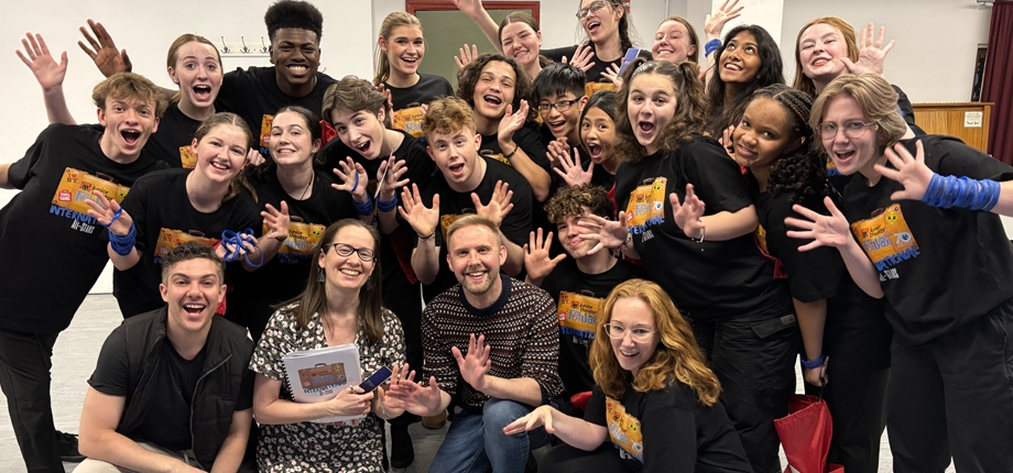 Children wearing black tshirts in jazz hands pose for camera